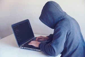 Protect your website, man in hoody trying to hack. 